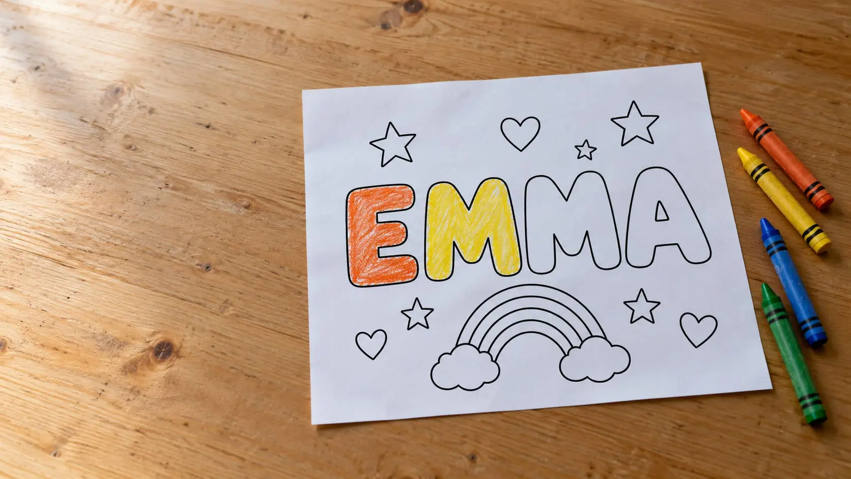 A printed EMMA name coloring page, partly colored with orange and yellow crayons